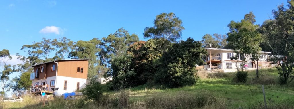 2 houses on a hill with trees